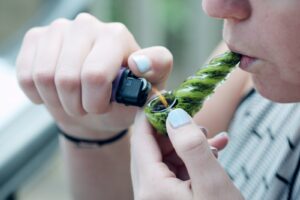 person holding lighting bowl with cannabis